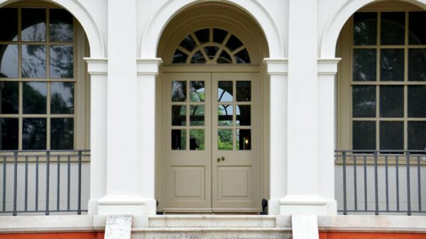 Beautiful archway with set back white door with panels for blog about front door inspiration in 2023.